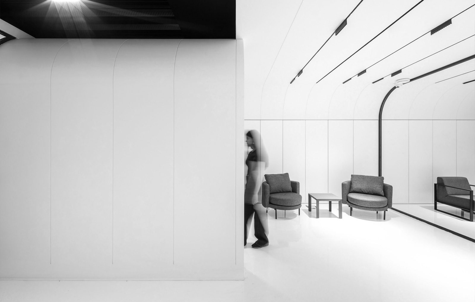 A long corridor of white arched portals with black frames at the EDC Office in Tehran